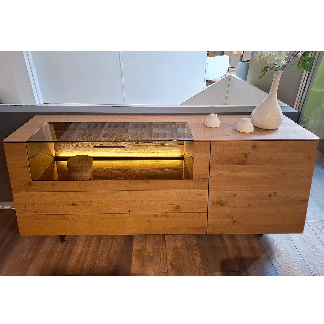 SALE_VARA.7210W-4181.1045_Sideboard.inkl.Beleuchtung Modernes Sideboard aus massiver Kerneiche Umato auf zwei Metallkufen mit beleuchtetem Glasausschnitt, Schubkasten und Holztür.